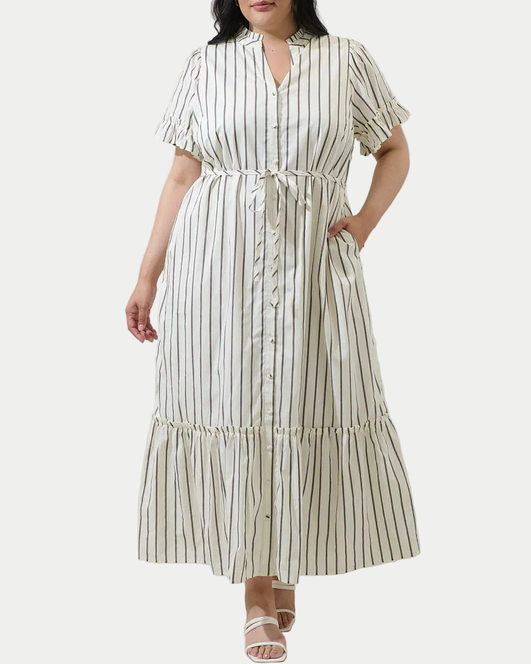 Woman wearing a striped dress against a plain background