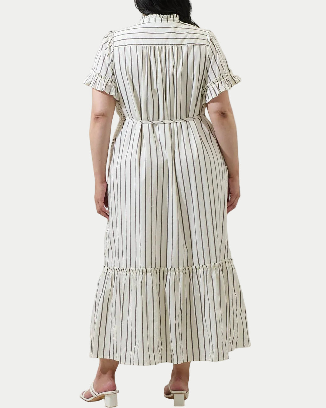Woman wearing a striped dress against a plain background