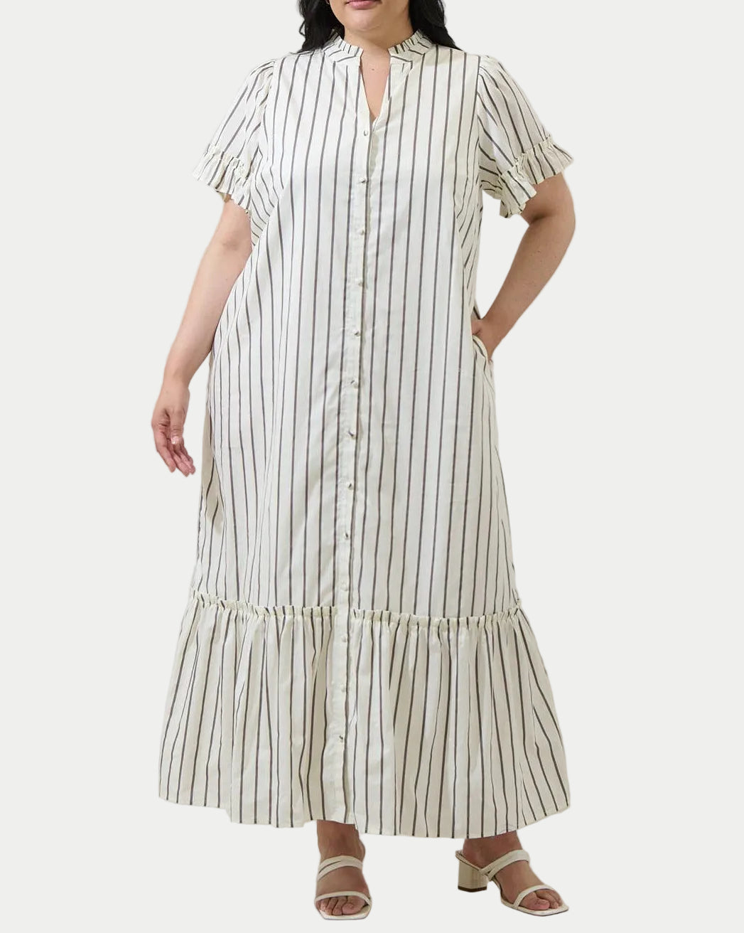 Woman wearing a striped dress against a plain background