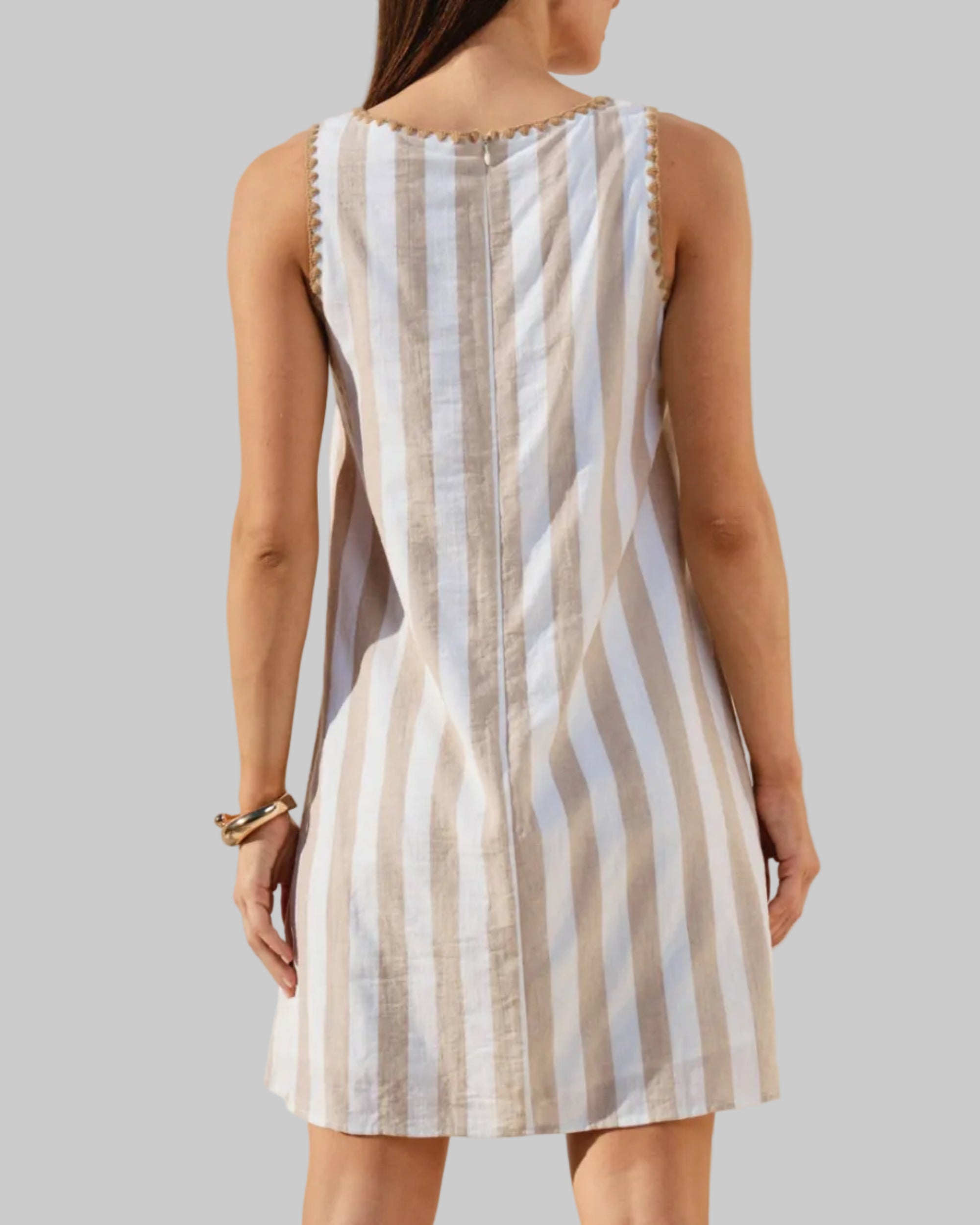 Vertical striped mini dress with whipstitch detail on a model with a neutral background. back view