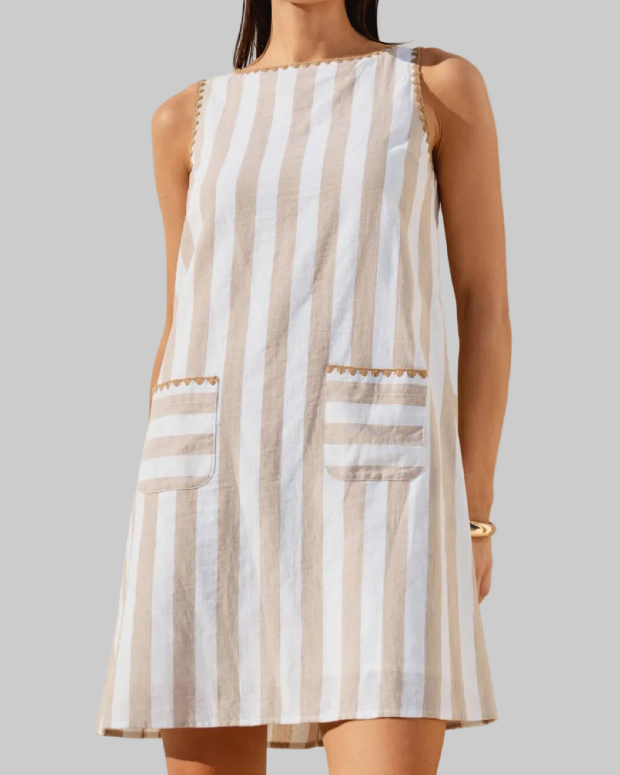Vertical striped mini dress with whipstitch detail on a model with a neutral background. front view