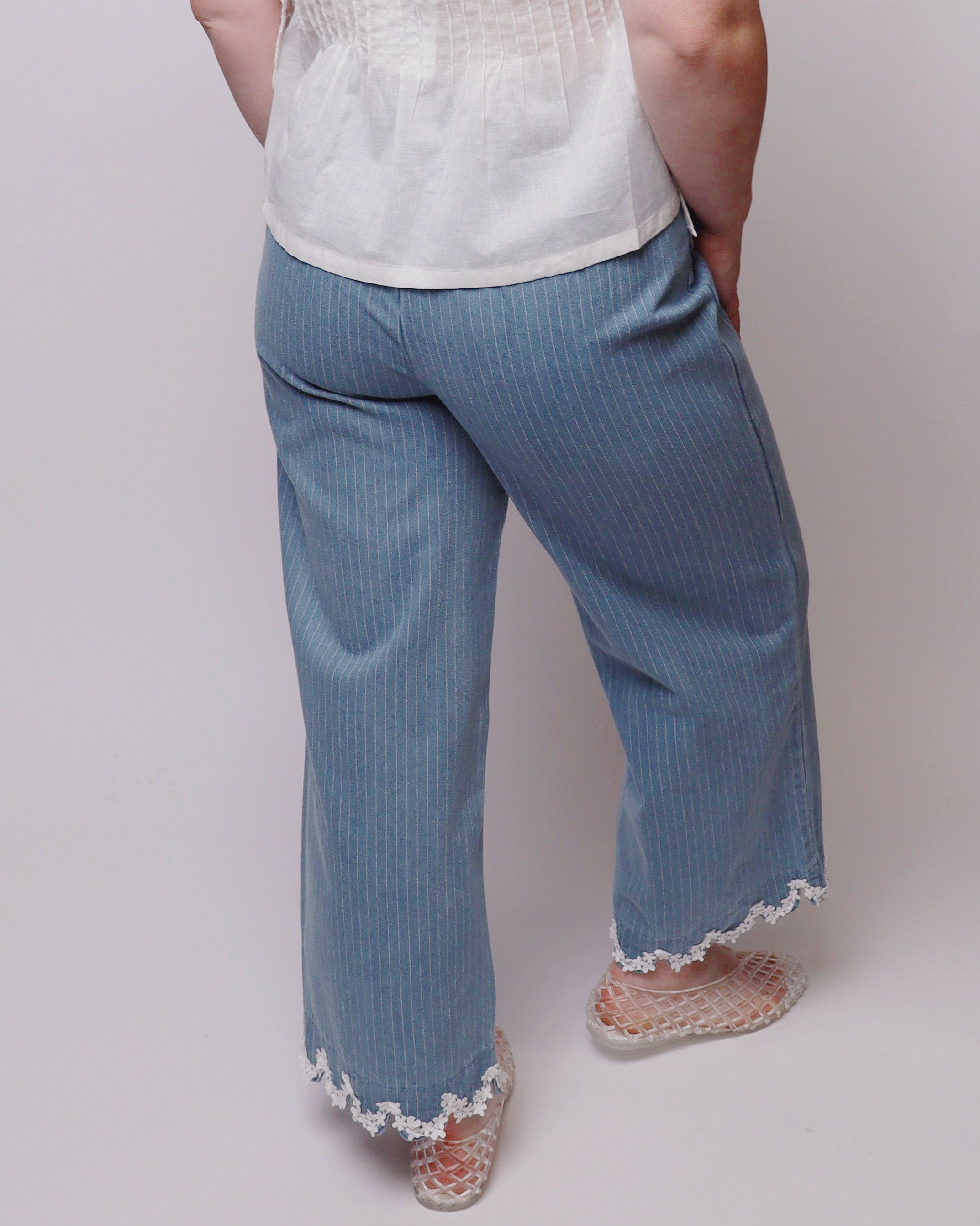 Light blue pants with lace trim worn by a person on a plain background