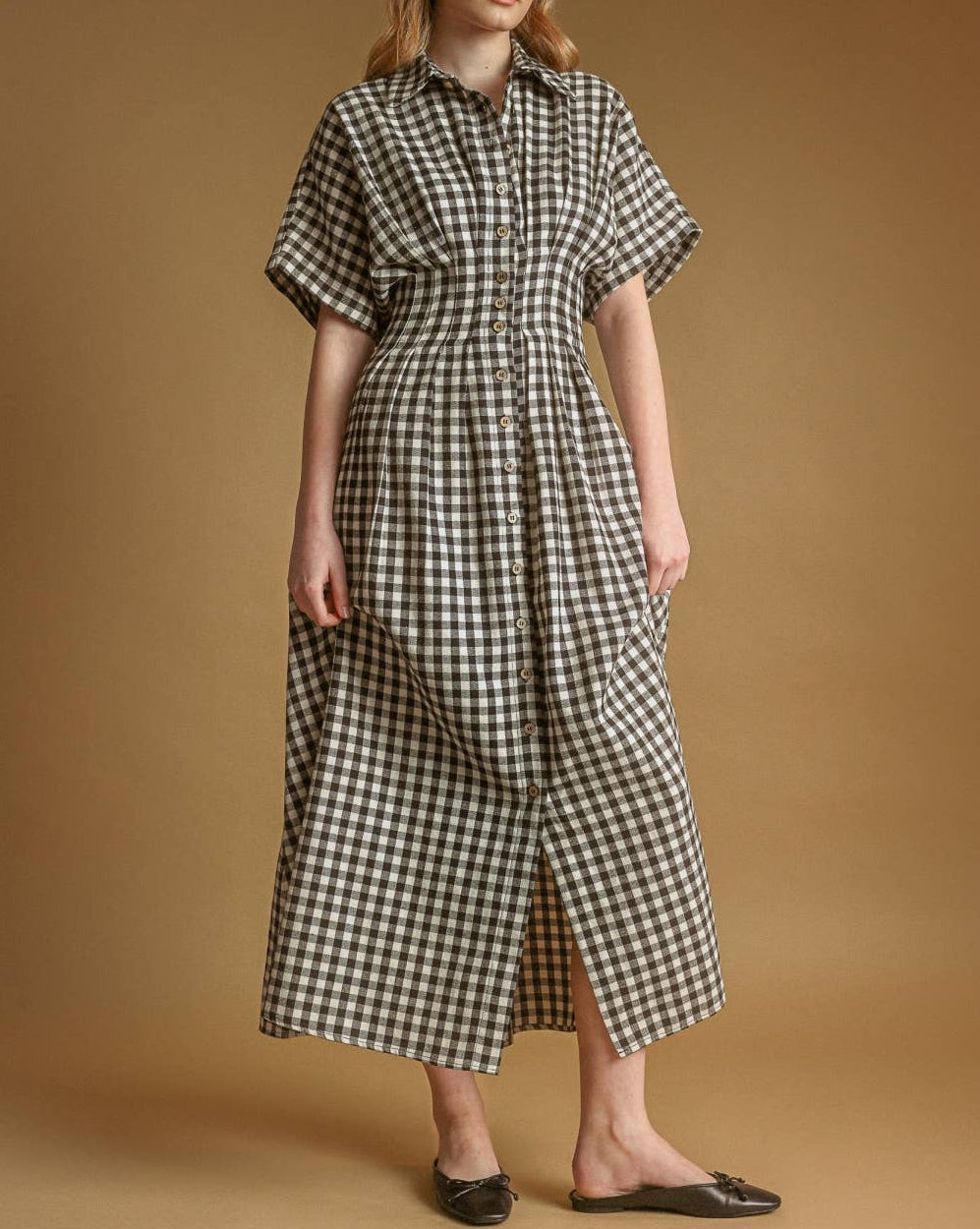 Woman wearing a checkered dress against a brown background