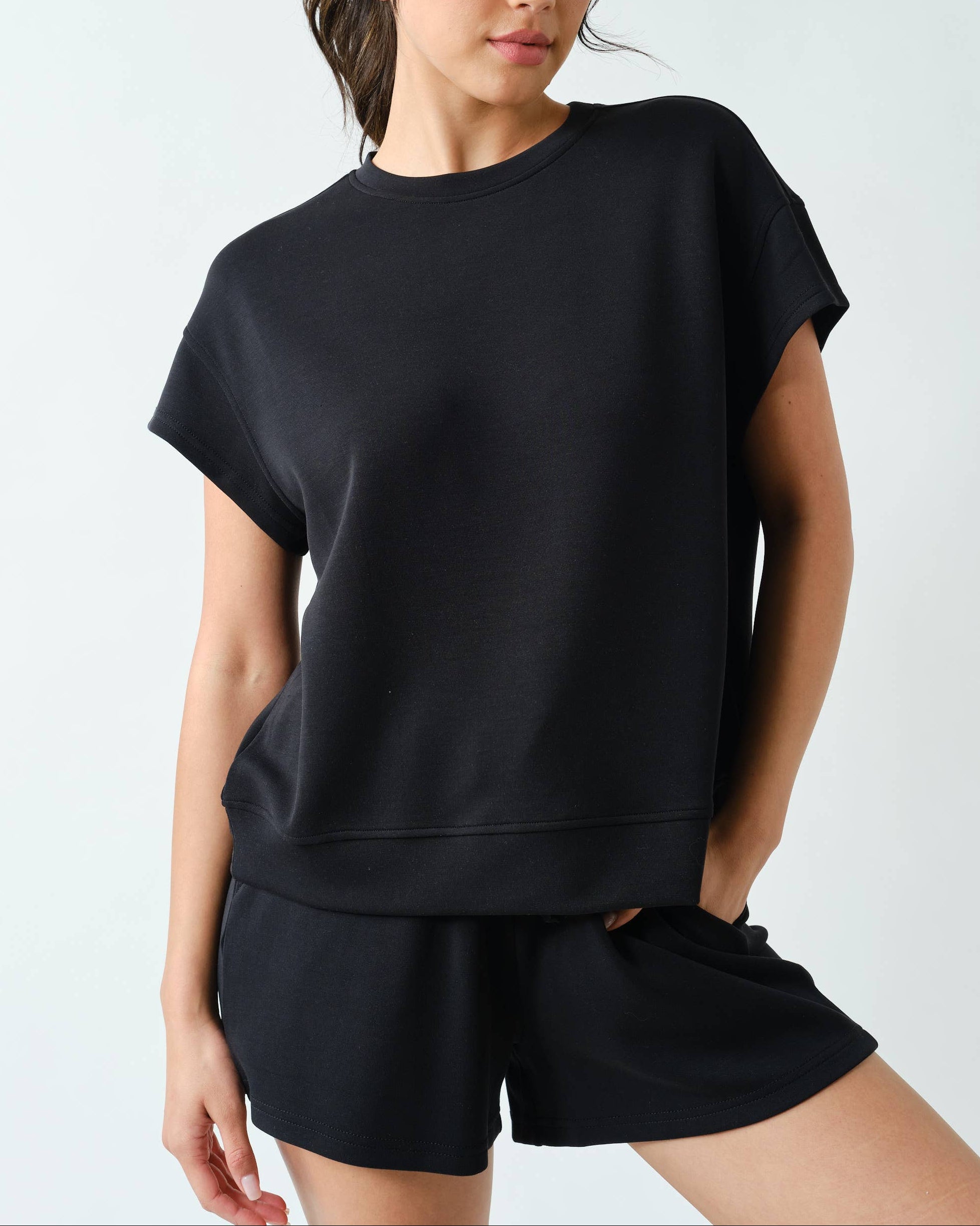 Model wearing a black shorts set outfit on a neutral background