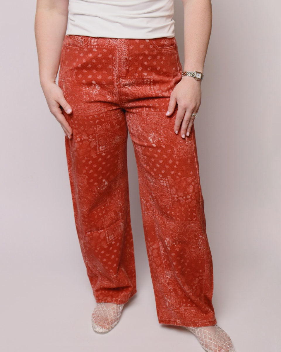 Person wearing red patterned pants on a plain background