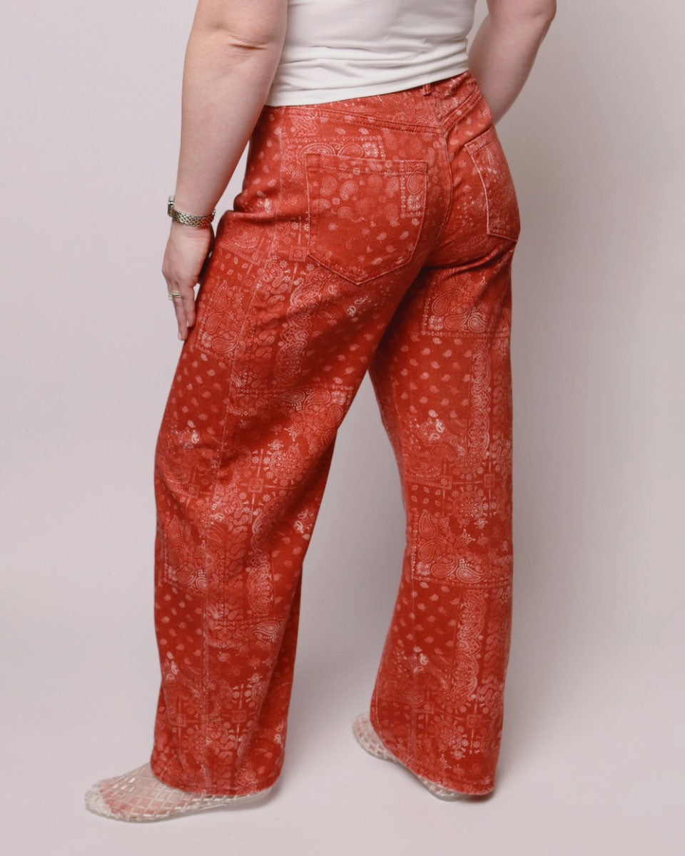 Person wearing red patterned pants on a plain background