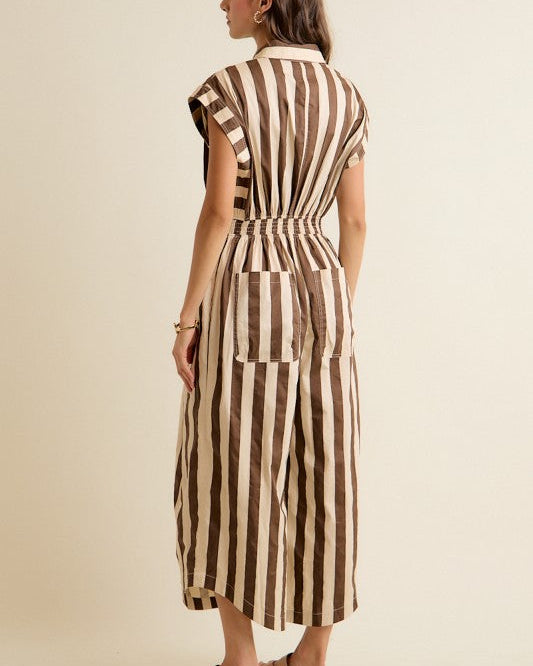 Woman wearing a striped jumpsuit against a beige background
