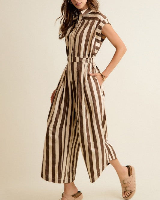 Woman wearing a brown and beige striped jumpsuit on a beige background