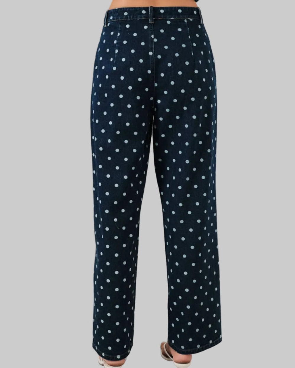 Navy blue pants with white polka dots on a gray background
