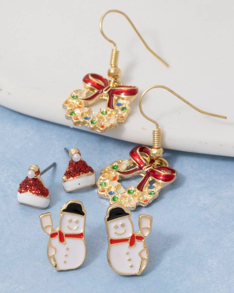 Set of Christmas-themed earrings including wreaths, snowmen, and Santa hats on a light blue background.