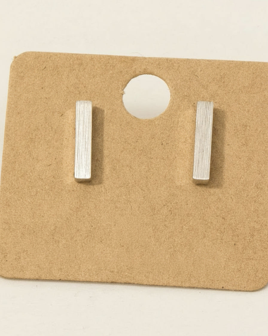 Pair of rhodium-plated bar earrings on a branded card.