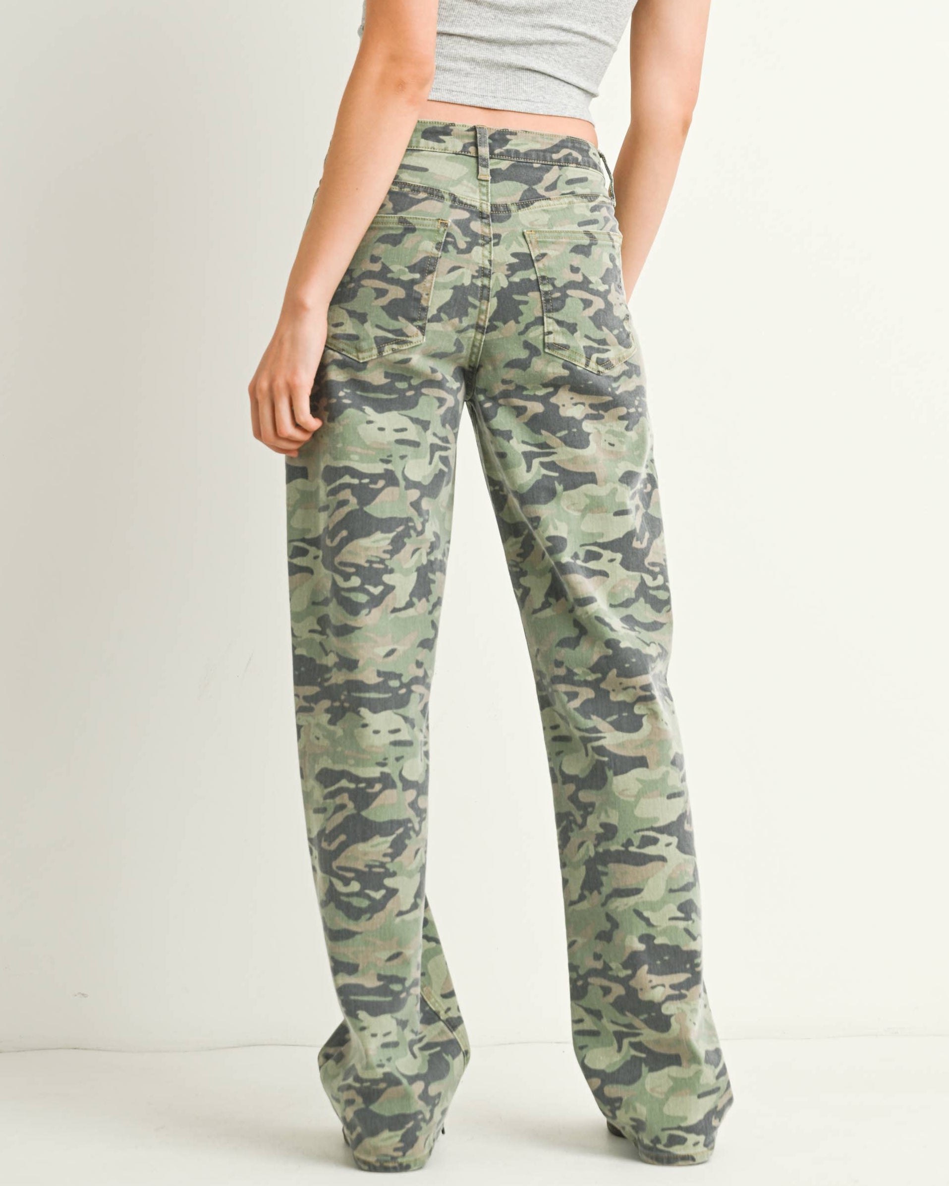 Woman wearing a gray tank top and camouflage pants on a white background