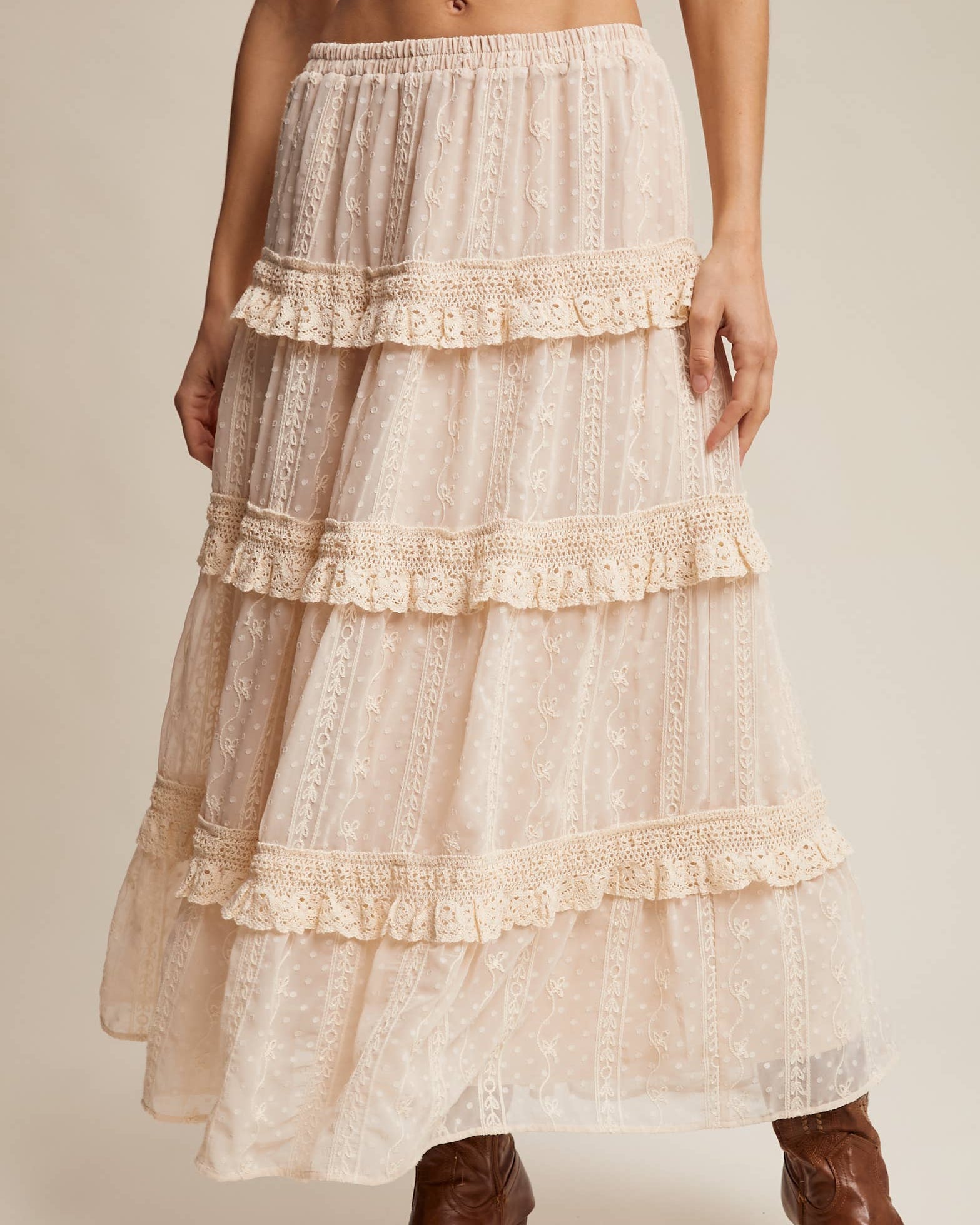 Beige lace skirt worn by a person on a beige background