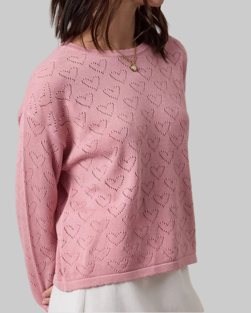 Woman wearing a pink patterned sweater against a beige background