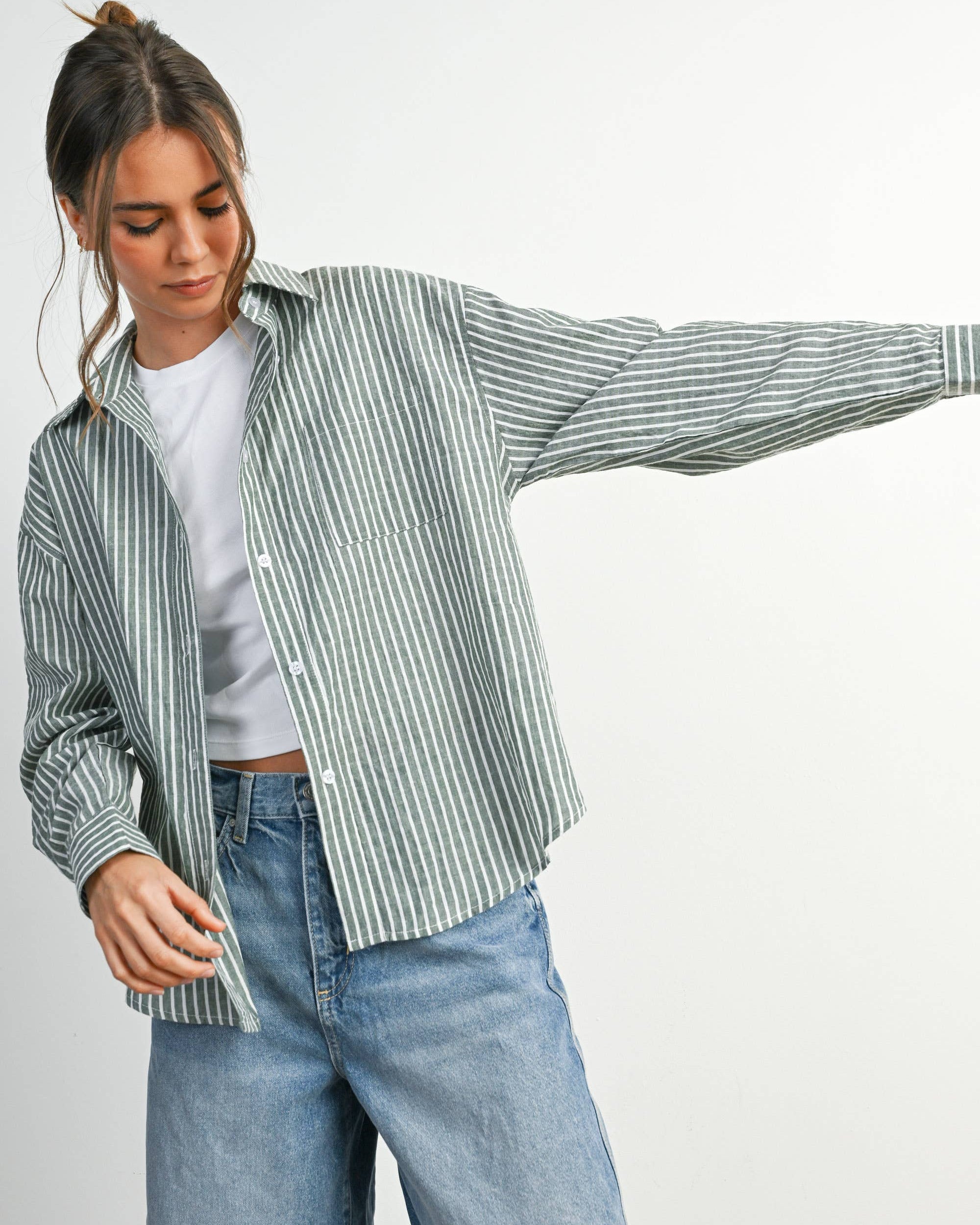 Woman wearing a striped shirt and jeans on a white background