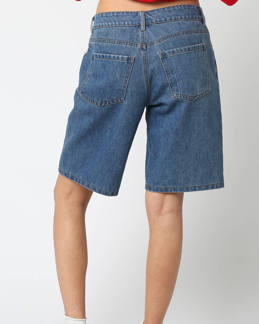 Blue denim shorts worn by a person on a white background