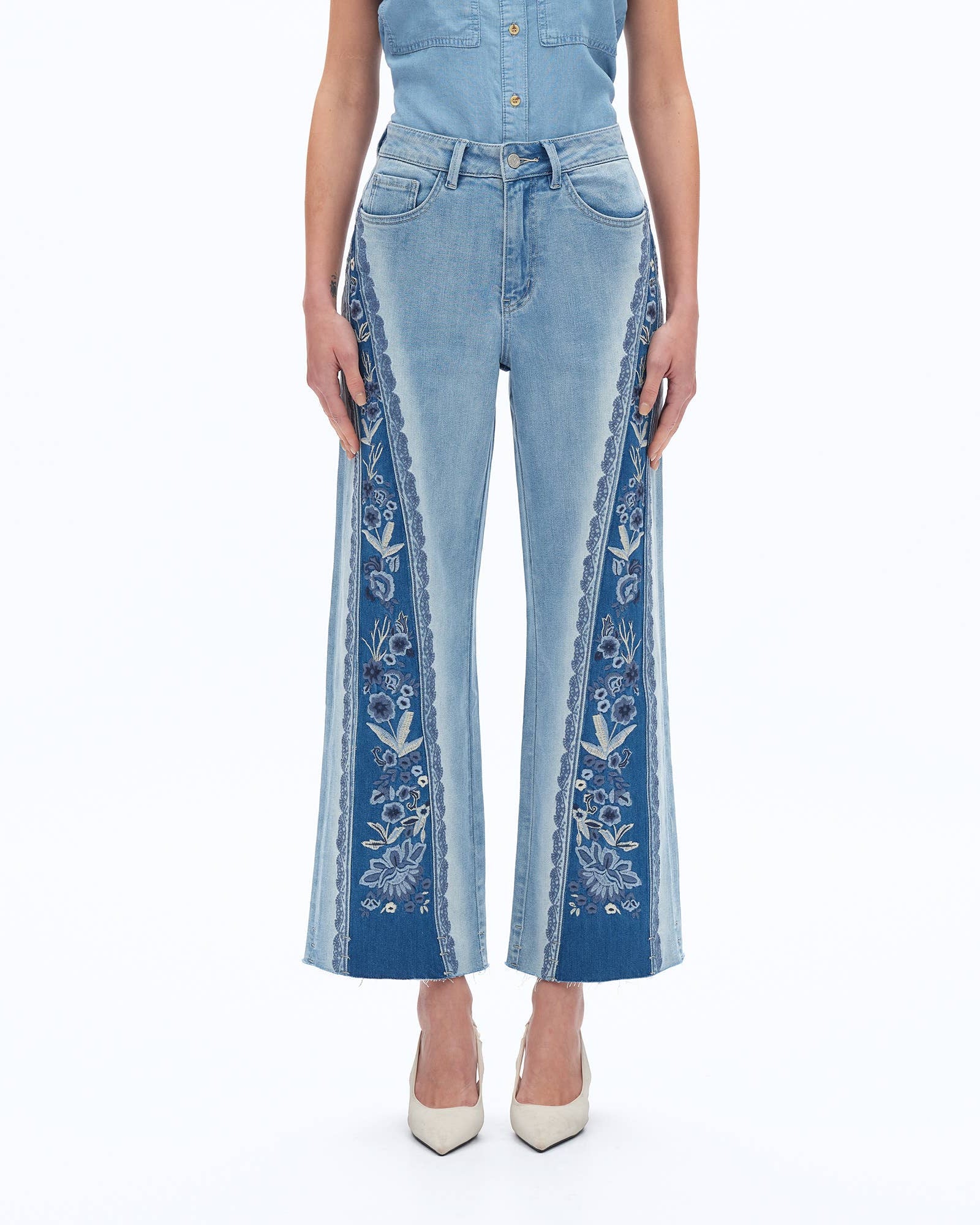 Blue jeans with floral embroidery on a white background