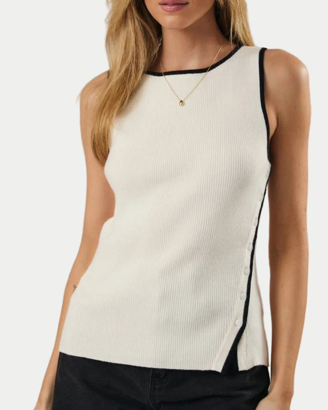 Woman wearing a white sleeveless top with black trim against a neutral background