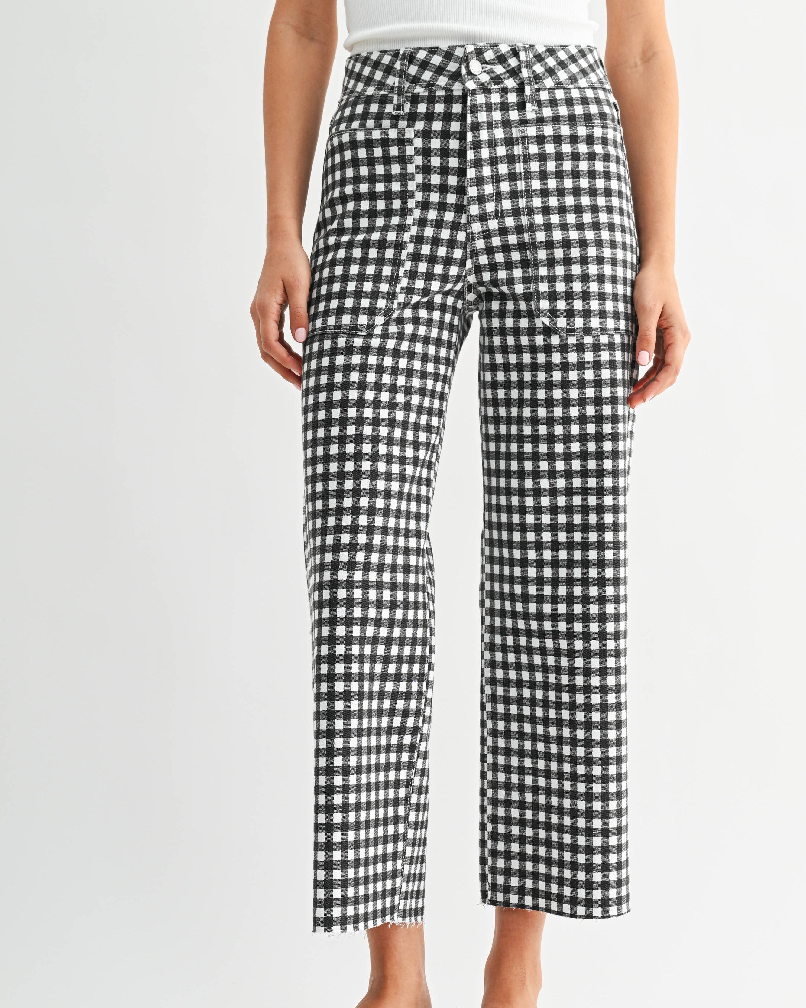 Person wearing black and white checkered pants on a white background