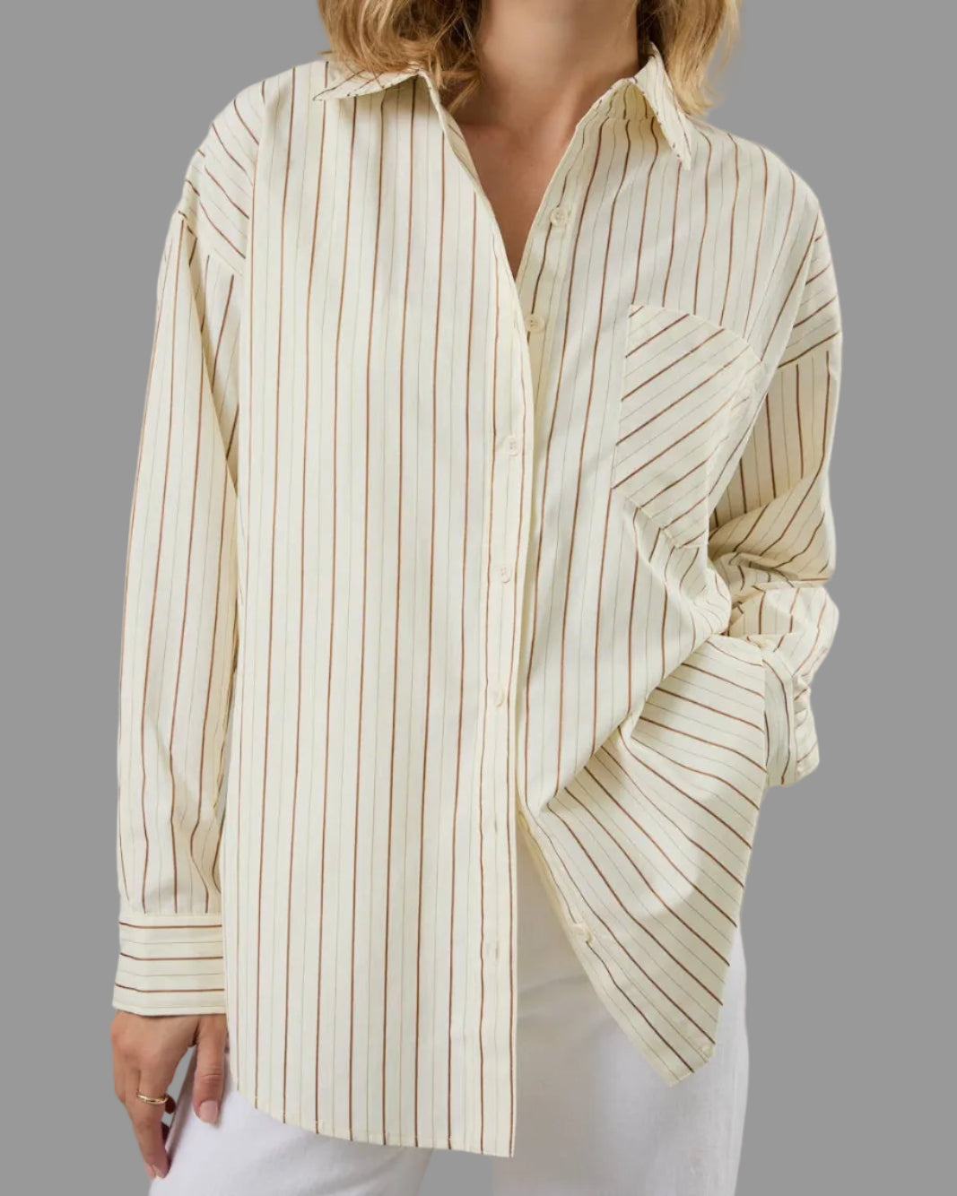 Woman wearing a striped shirt with rolled-up sleeves against a neutral background