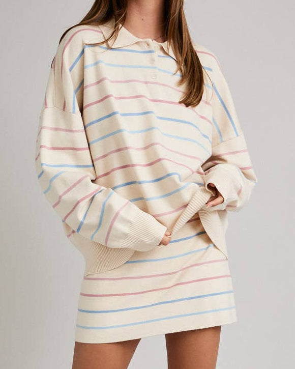 Woman wearing a striped dress and red boots on a plain background