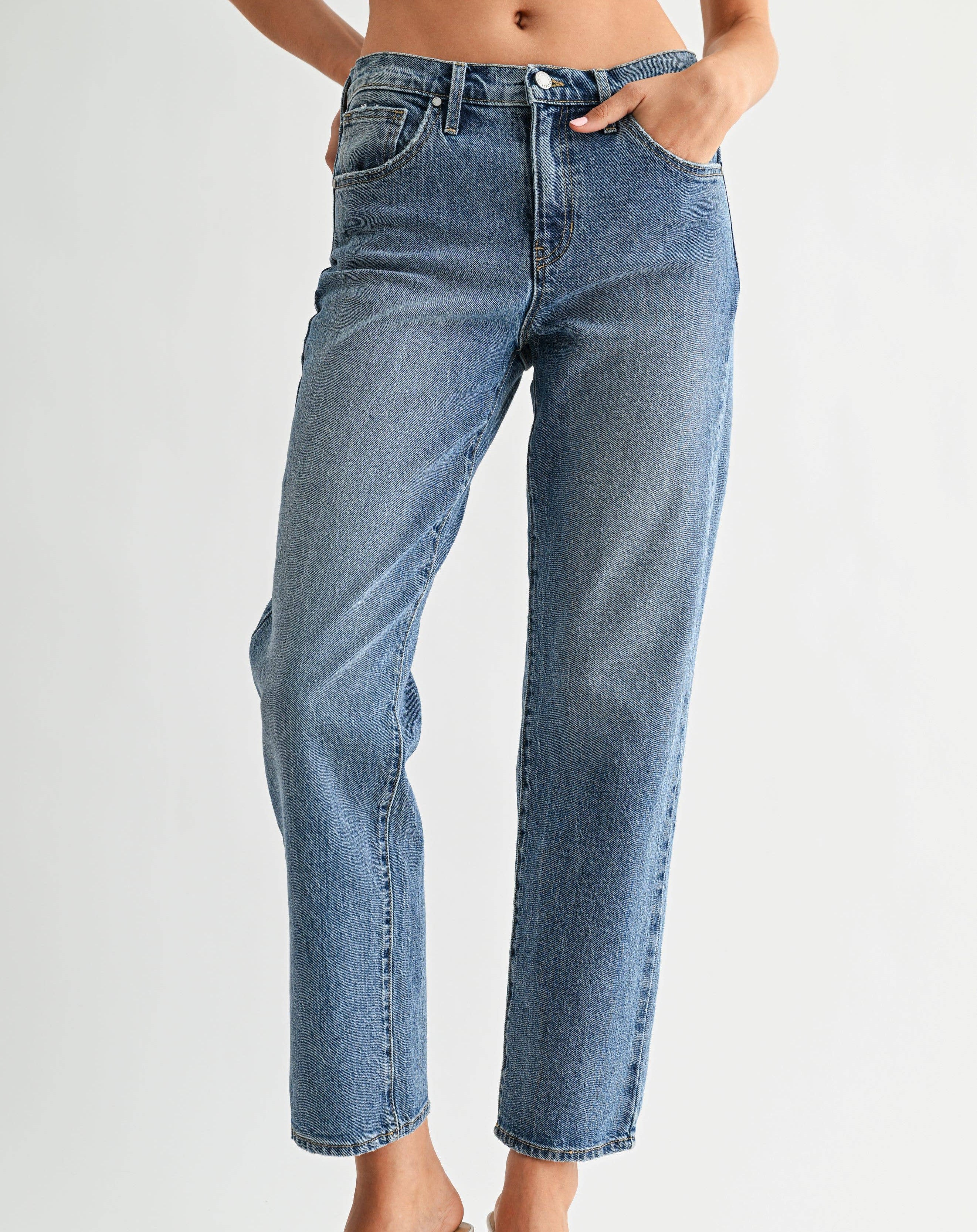 Person wearing blue jeans on a plain background