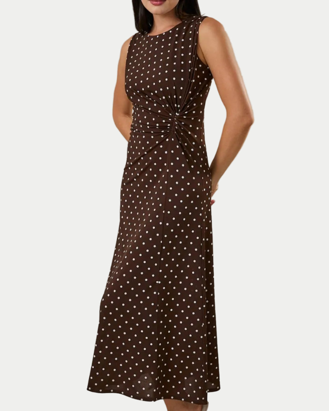 ROUND NECK GATHERED SIDE KNOT POLKA DOT MIDI DRESS ON A MODEL WITH A WHITE BACKGROUND- Blackbird Boutique