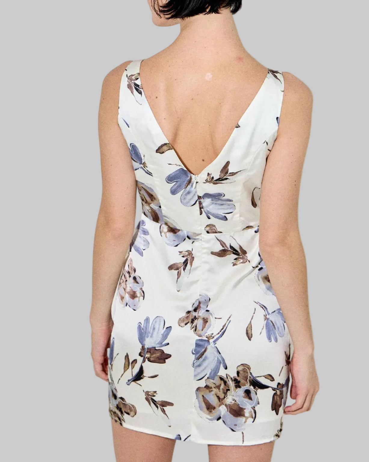 Woman wearing a floral dress with a plain background