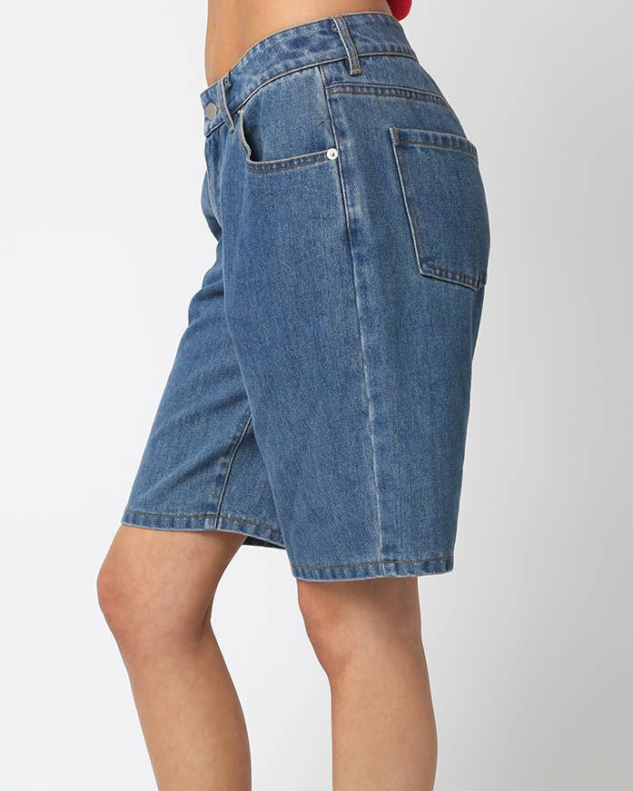 Person wearing a blue denim skirt on a white background