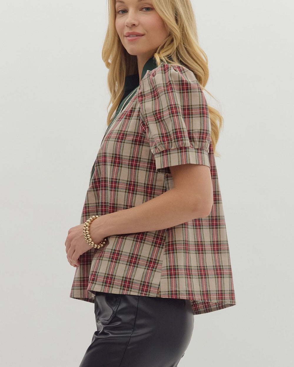 Woman wearing a plaid jacket on a plain background