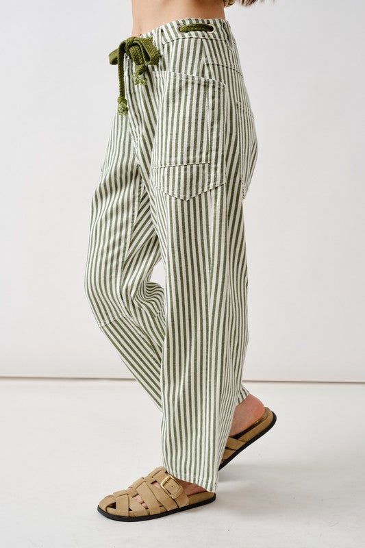 Green and white striped pants worn by a person on a white background
