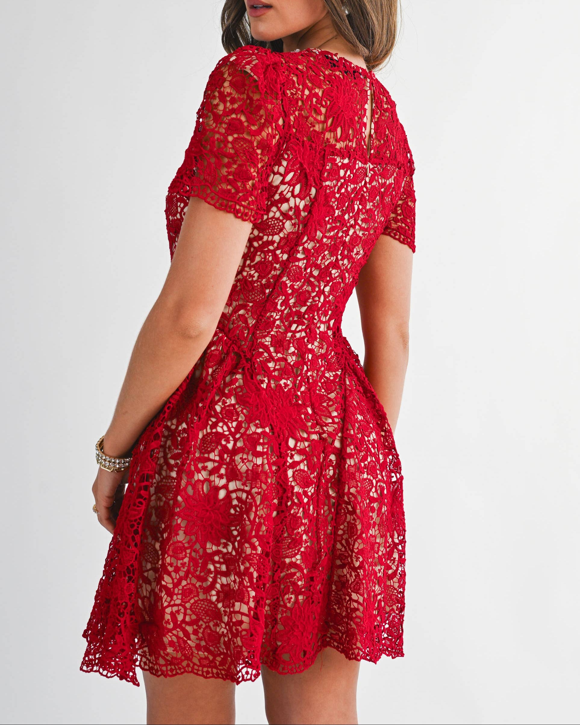 Woman wearing a red lace dress on a white background