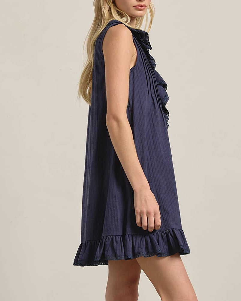 Woman wearing a navy blue dress against a plain background