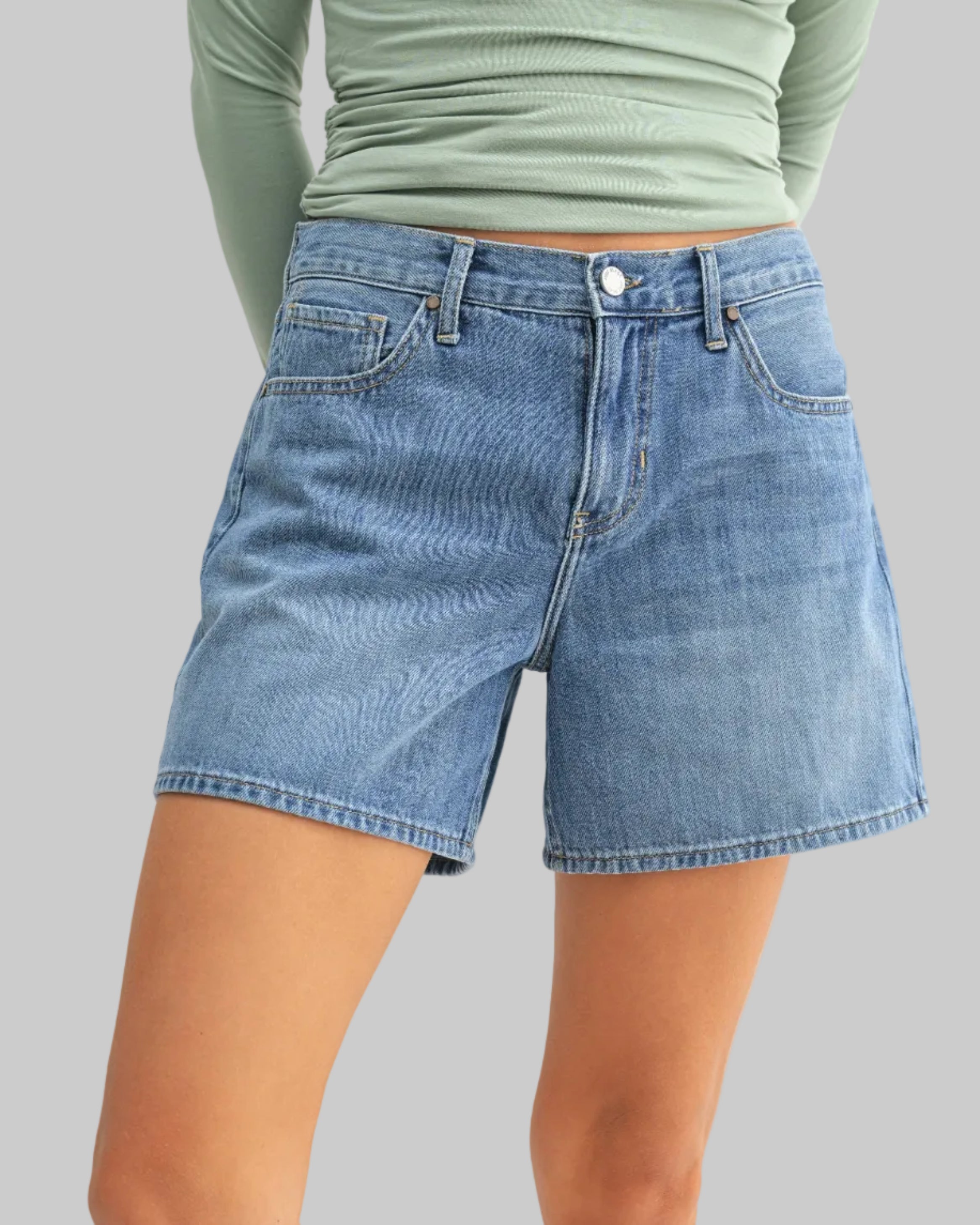 Person wearing blue denim shorts on a plain background