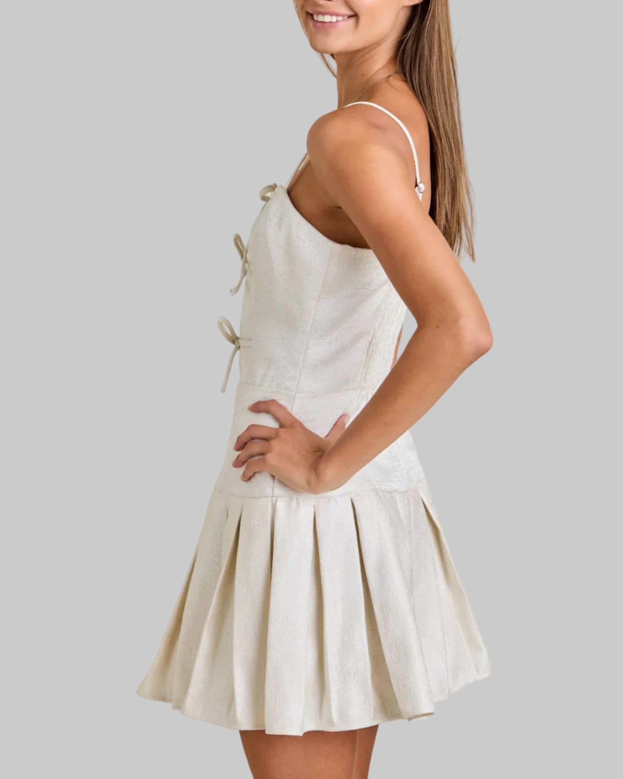 Woman wearing a white dress against a beige background