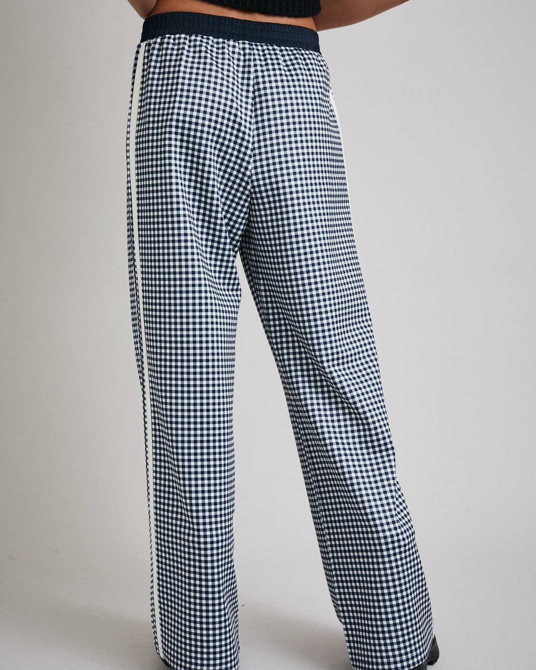 Houndstooth patterned pants worn by a person on a plain background