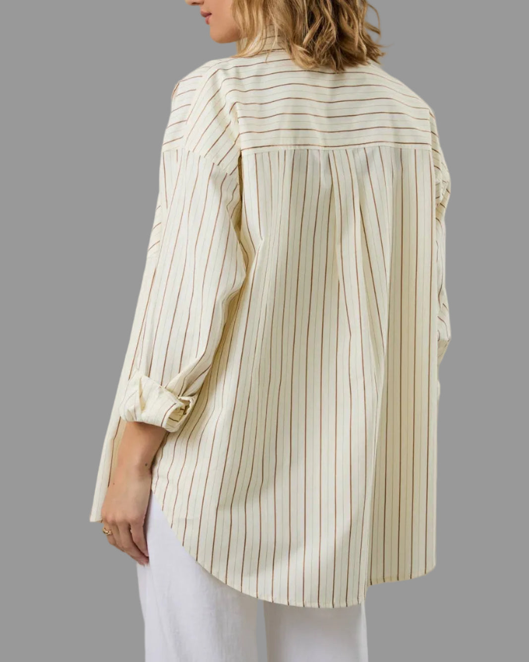 Woman wearing a beige and white striped shirt against a plain background