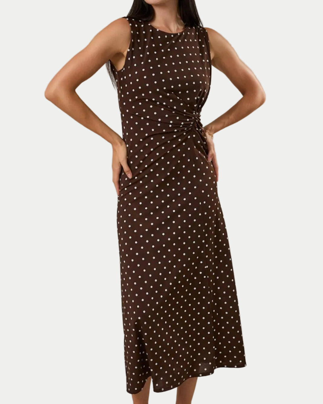 ROUND NECK GATHERED SIDE KNOT POLKA DOT MIDI DRESS  ON A MODEL WITH A WHITE BACKGROUND- Blackbird Boutique