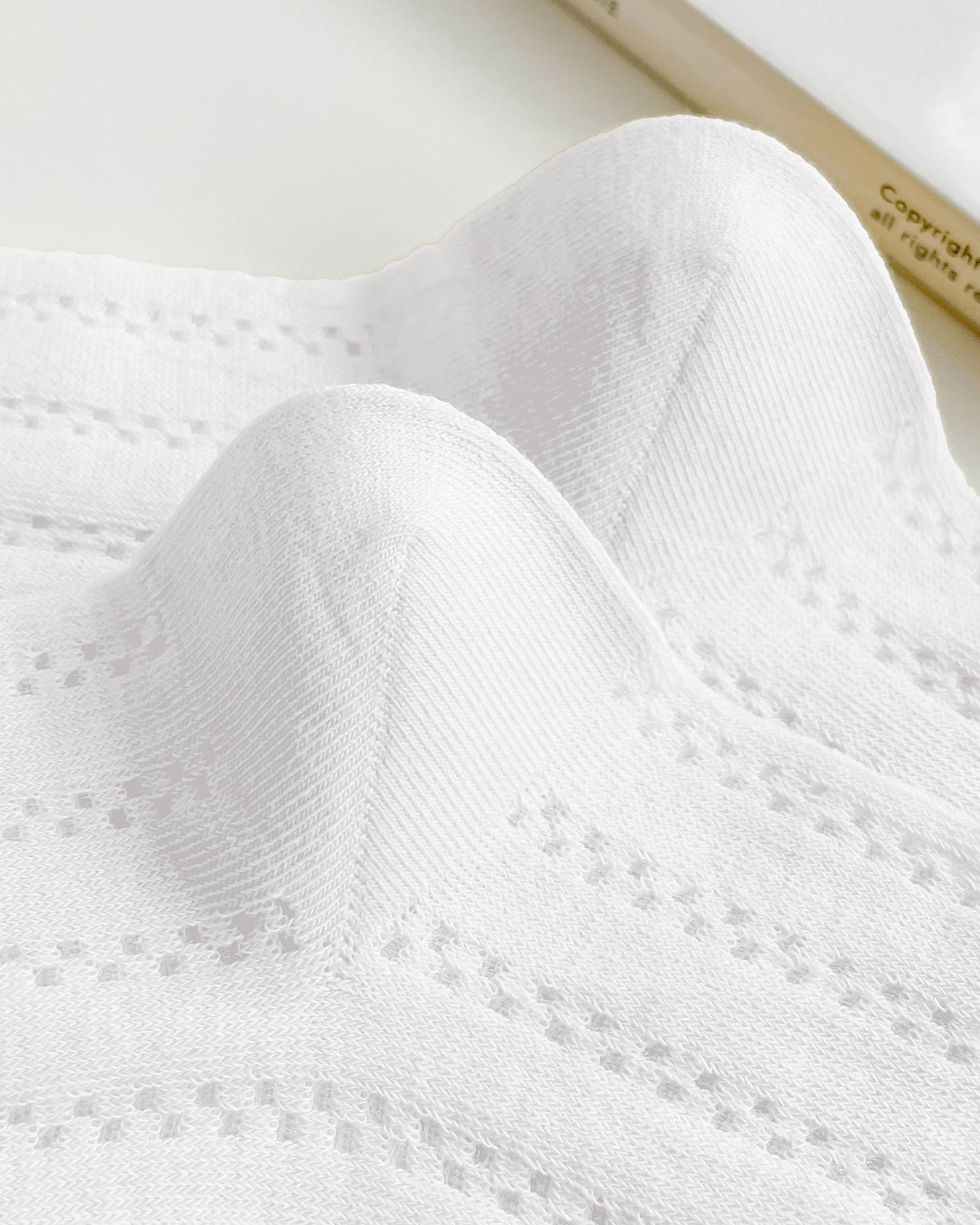 Close-up of white textured fabric with a blurred background