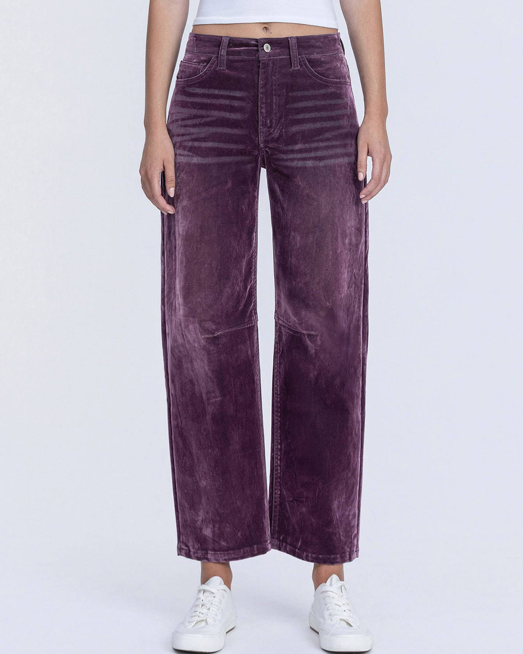 Purple velvet pants worn by a person on a white background