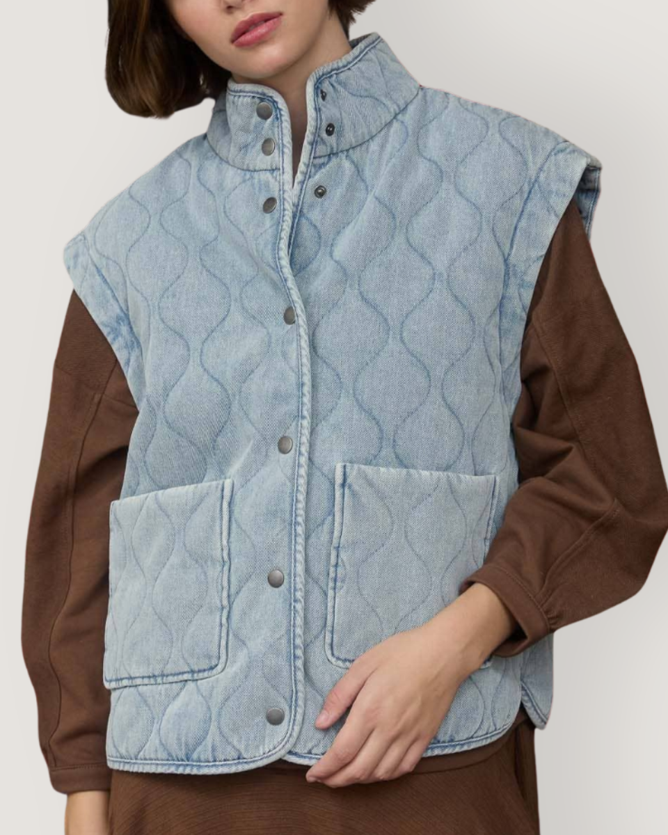 Person wearing a light blue quilted vest over a brown shirt on a white background-Blackbird Boutique