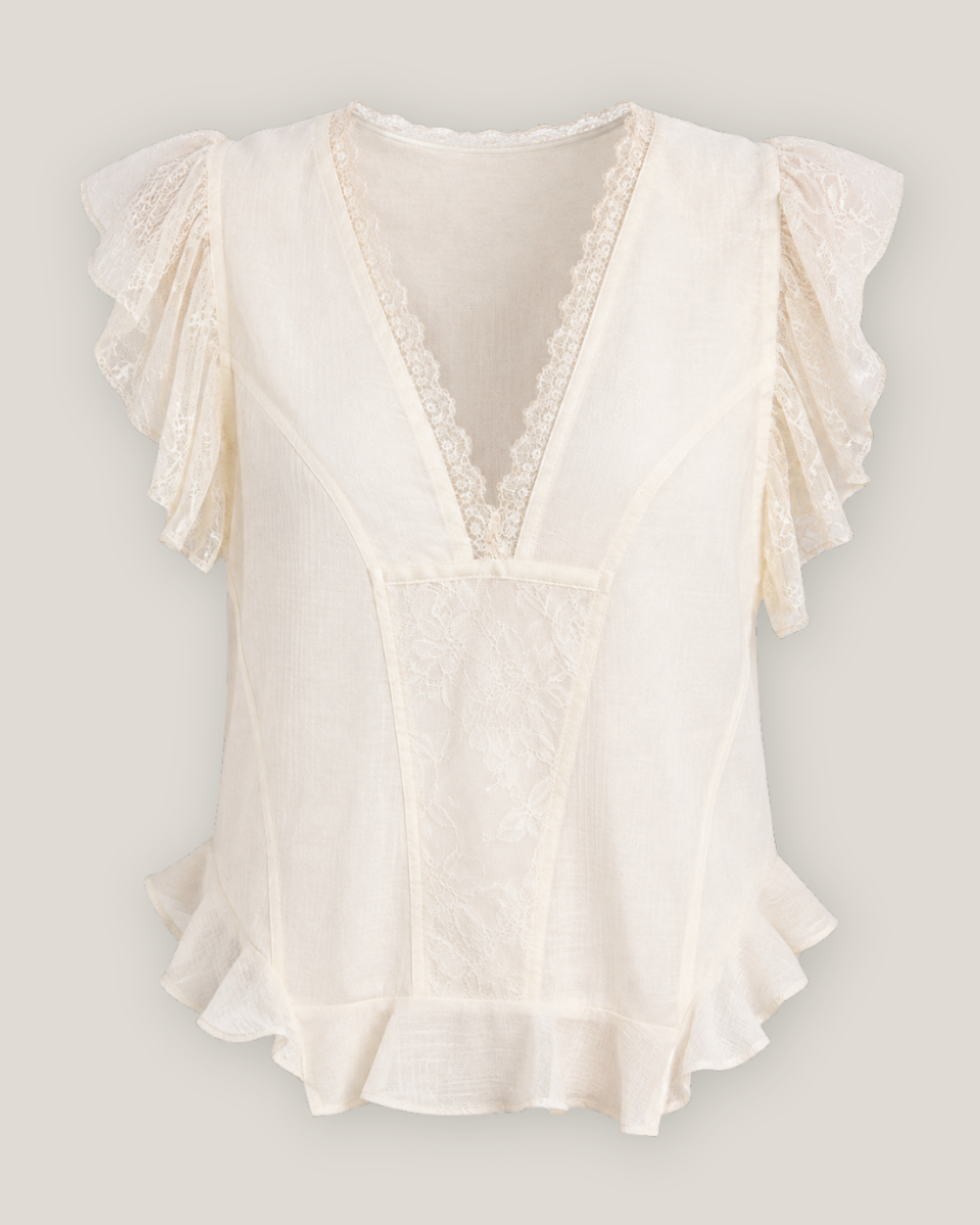 An off-white lace and cotton blouse with ruffled sleeves, a deep V-neckline, and a ruffled hem, shown against a solid light gray background.