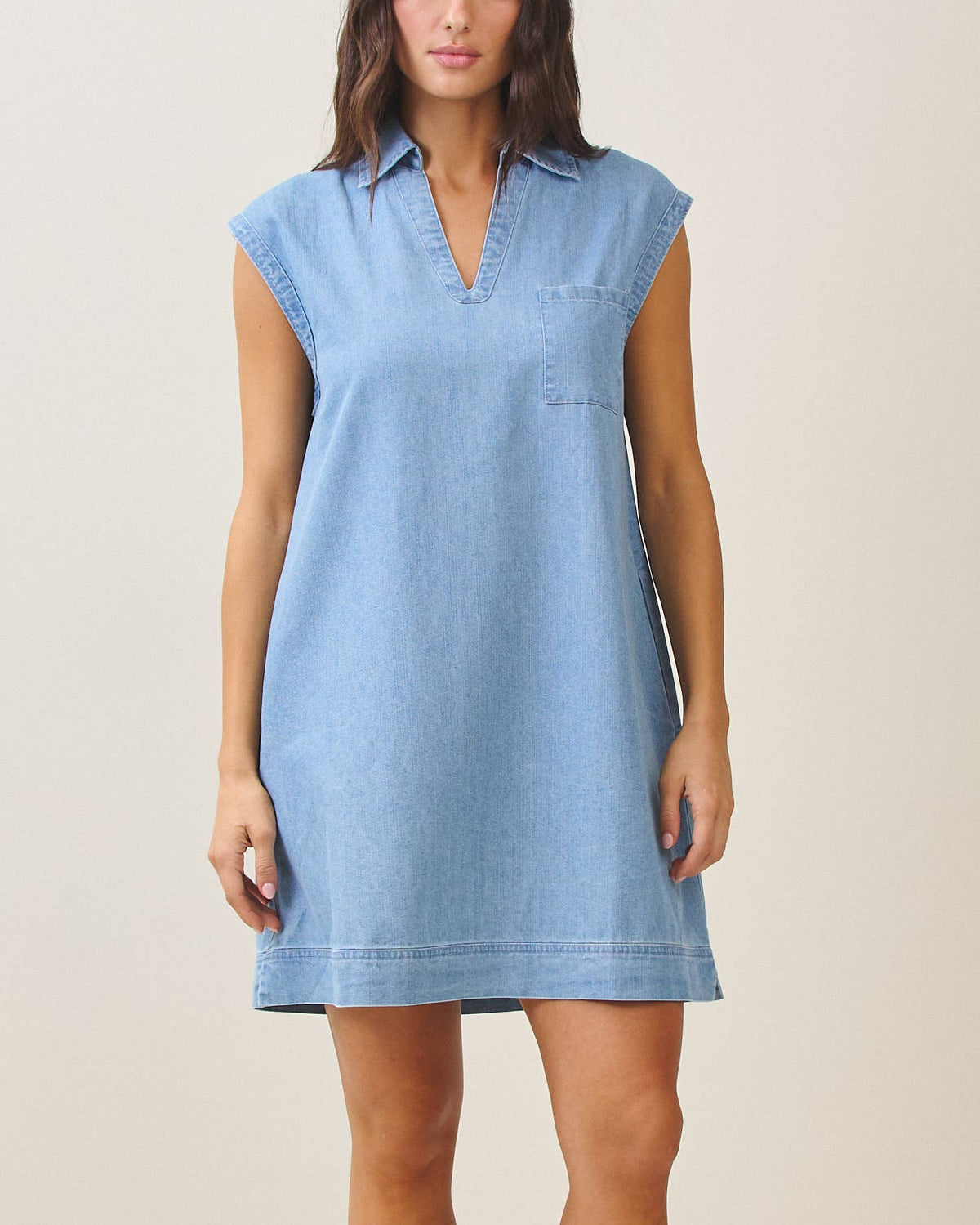 Woman wearing a light blue dress against a plain background