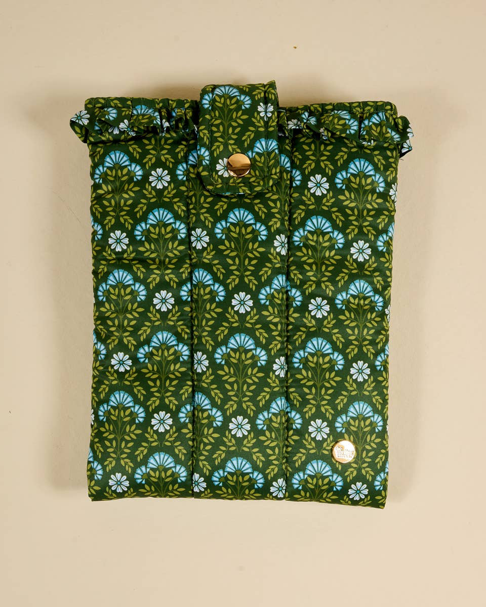 Green and blue patterned quilted book cover bag on a beige background