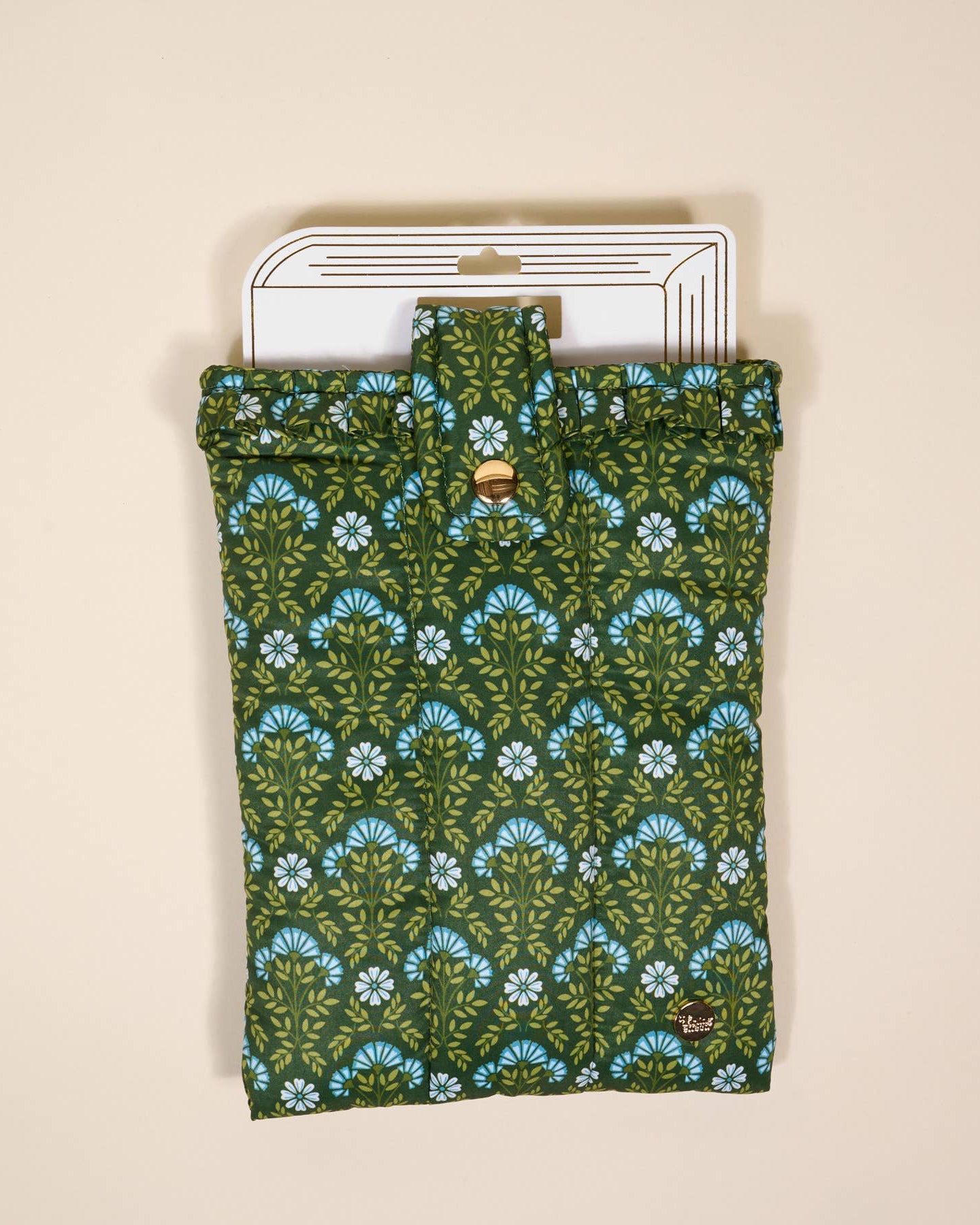 Green floral patterned quilted book cover pouch with a button on a beige background
