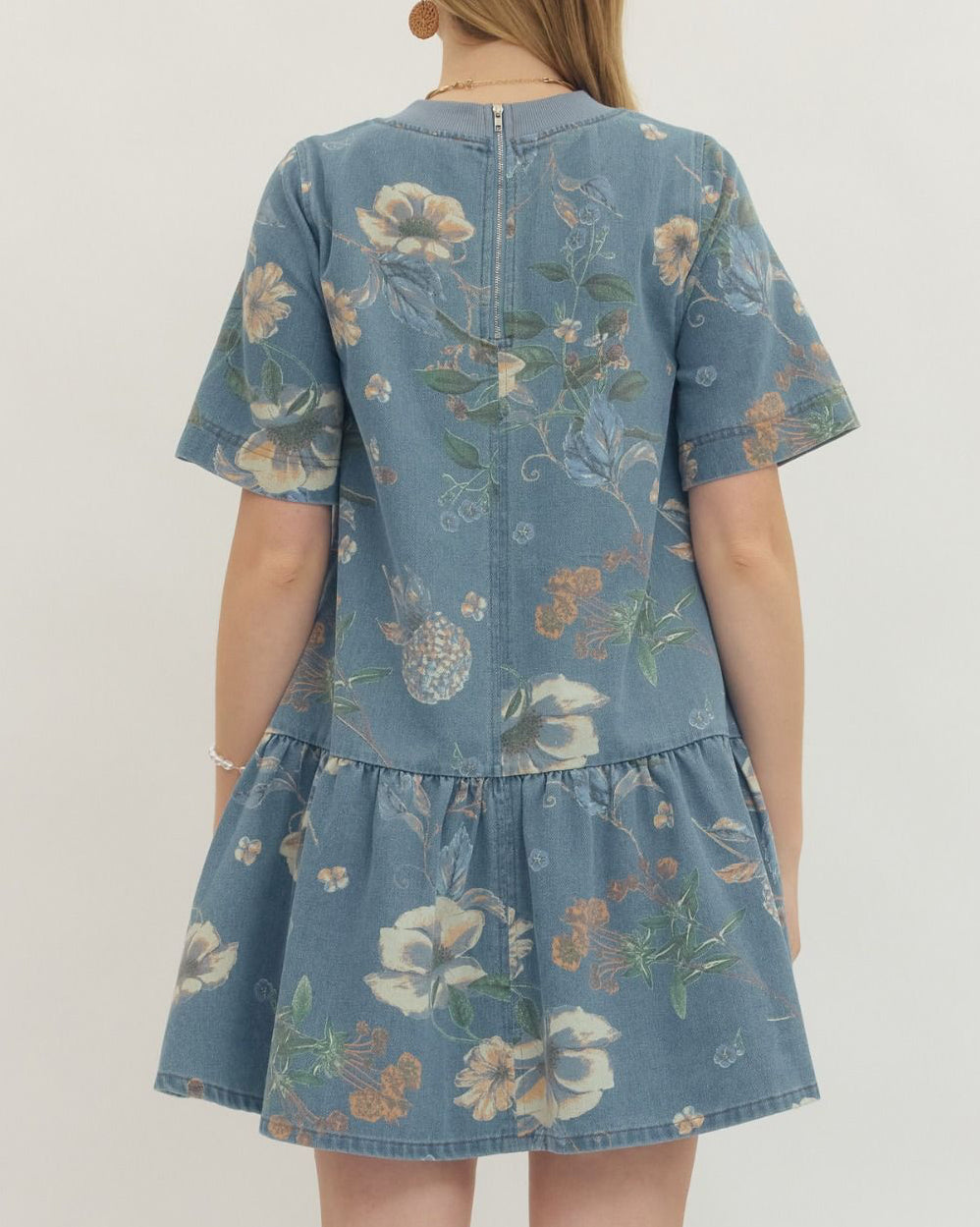 Child wearing a blue floral dress against a white background