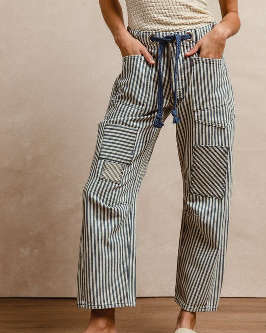 Person wearing striped pants with a neutral background