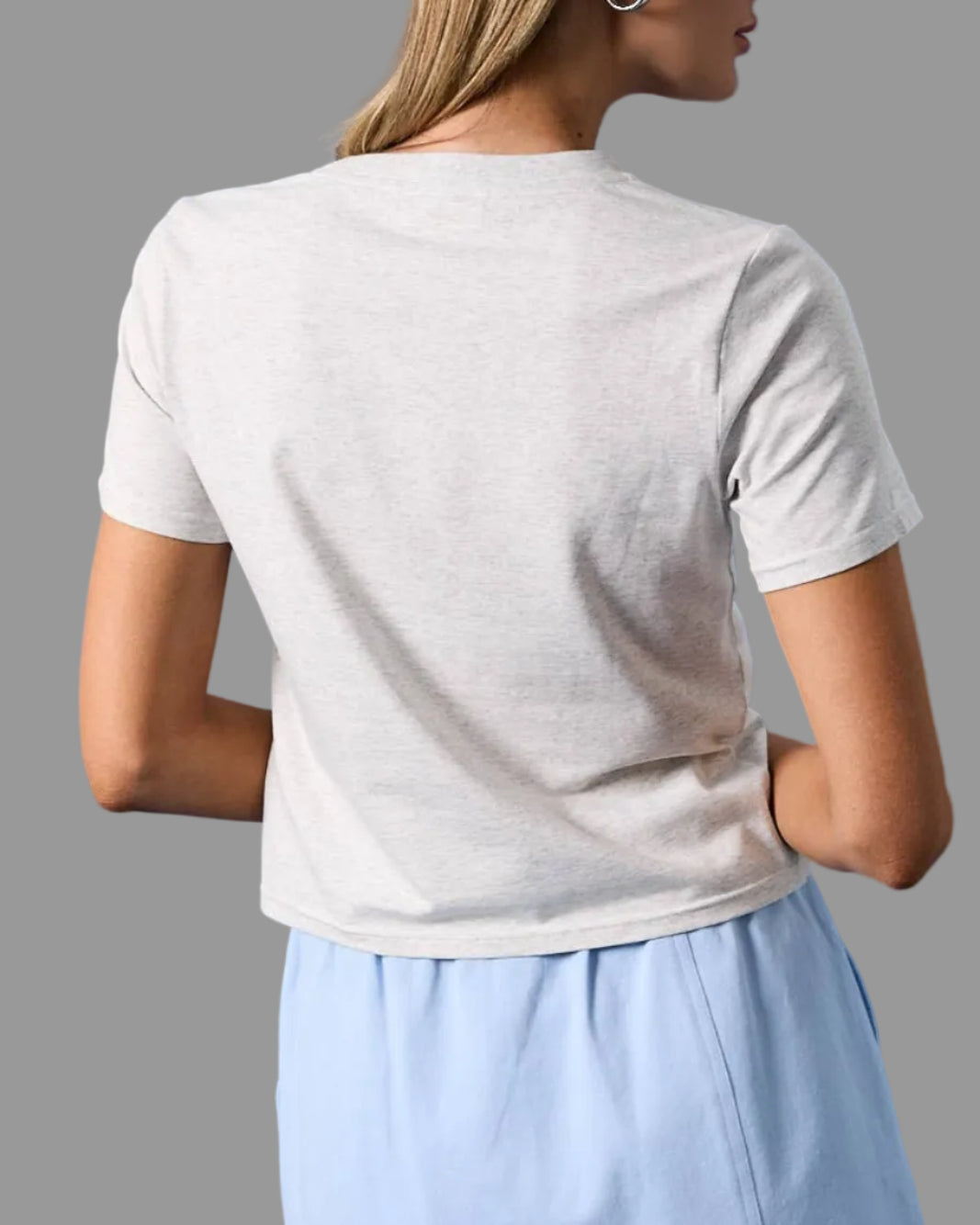 Model wearing a white t-shirt with a USA Dog embroidered graphic design with a neutral background back view