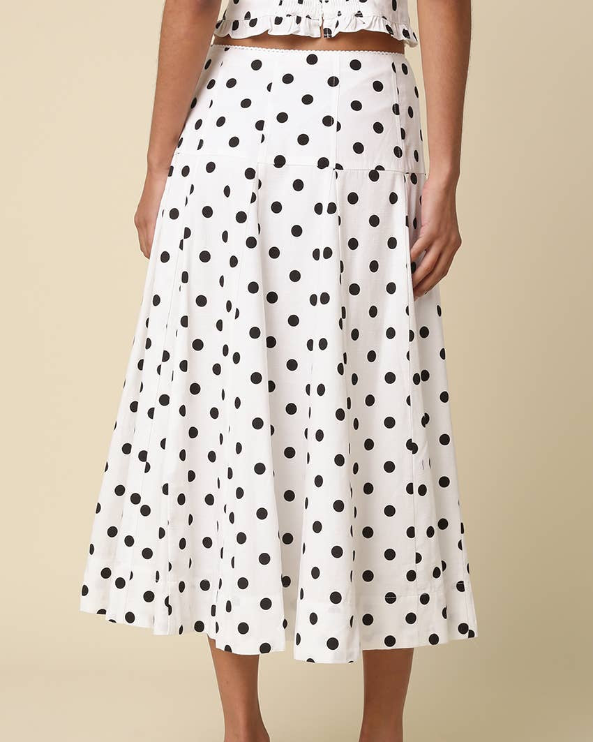 White with black Polka Dot Midi Skirt worn on a model with a neutral background- Blackbird Boutique side view