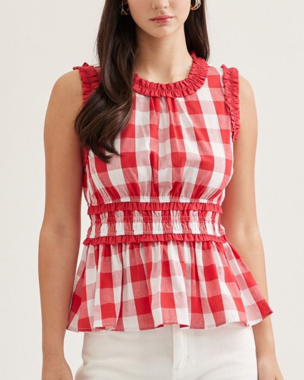 Model wearing a red and white Gingham peplum top with ruffled details on a neutral background